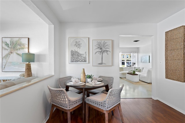 dining space with baseboards and hardwood / wood-style floors