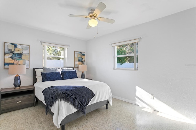 bedroom featuring speckled floor, a ceiling fan, and baseboards