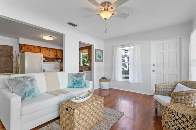 living area featuring ceiling fan, visible vents, baseboards, and dark wood-type flooring