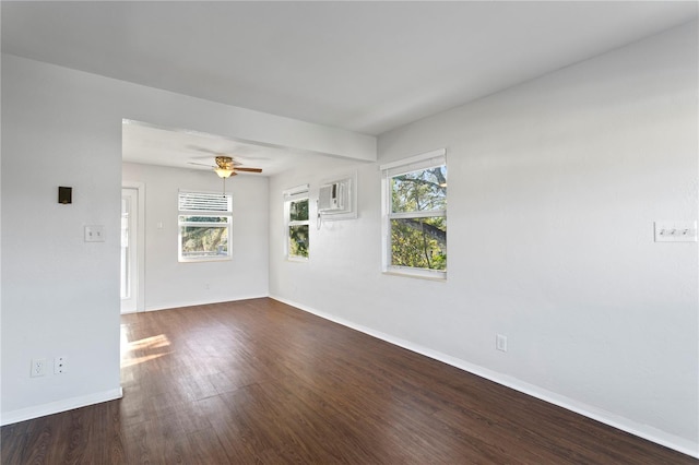 spare room with a healthy amount of sunlight, baseboards, dark wood finished floors, and a ceiling fan