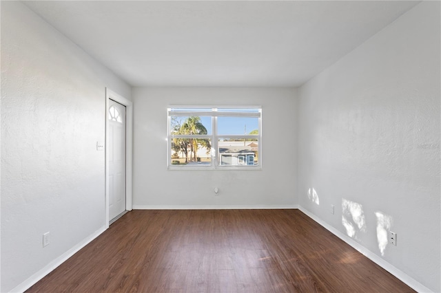 unfurnished room featuring baseboards and wood finished floors