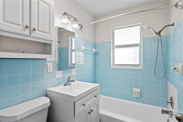 full bath with  shower combination, tile walls, toilet, and vanity