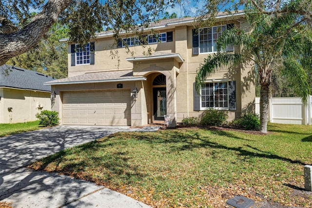 traditional-style home featuring a garage, fence, concrete driveway, stucco siding, and a front yard