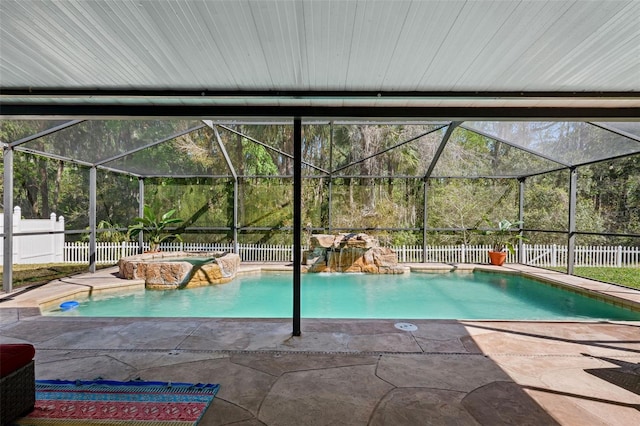 view of pool featuring a lanai, a fenced backyard, a pool with connected hot tub, and a patio