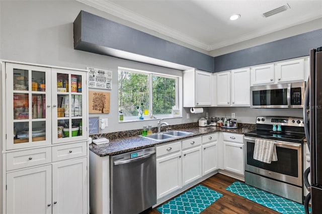 kitchen with a sink, visible vents, white cabinetry, ornamental molding, and appliances with stainless steel finishes