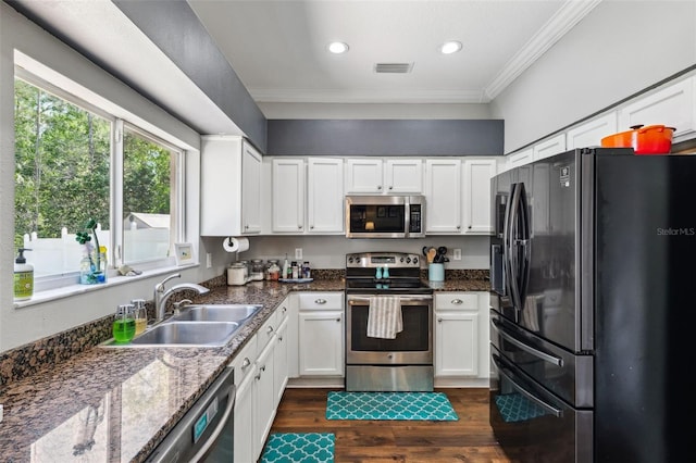 kitchen with stainless steel appliances, visible vents, a sink, and ornamental molding