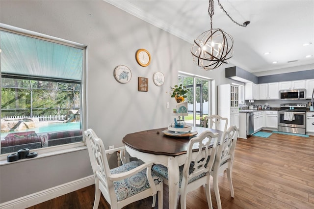 dining area featuring crown molding, recessed lighting, wood finished floors, a chandelier, and baseboards