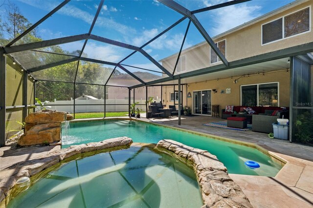 view of swimming pool featuring a pool with connected hot tub, outdoor lounge area, fence, and a patio