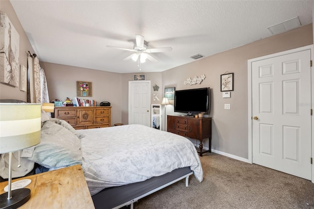 bedroom with baseboards, a textured ceiling, visible vents, and carpet flooring