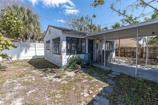 view of front of property featuring fence and a carport