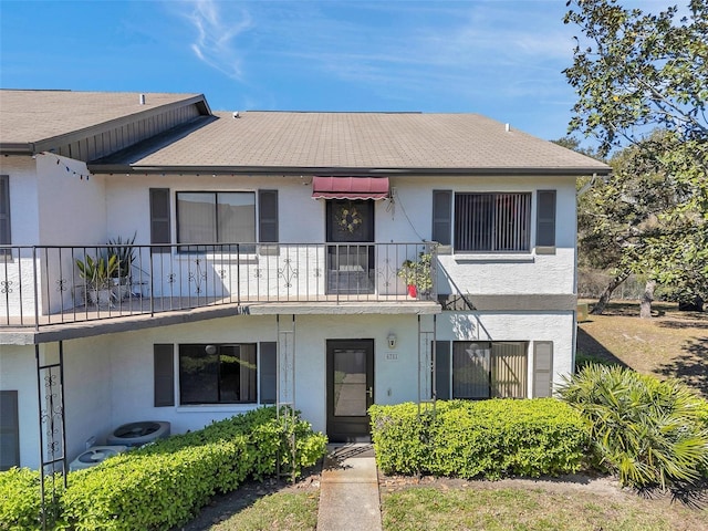 multi unit property featuring a balcony, central AC, and stucco siding