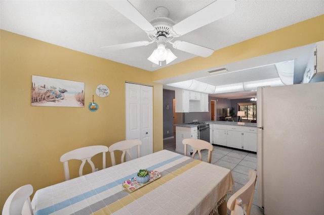 dining room with light tile patterned floors, visible vents, and a ceiling fan