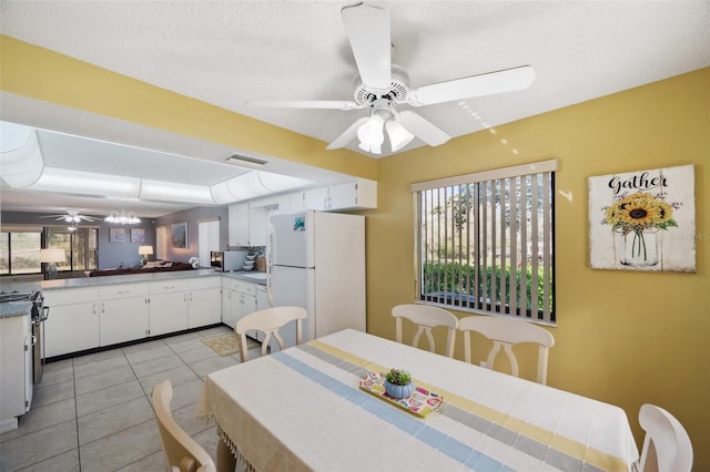 dining space featuring a ceiling fan, visible vents, a textured ceiling, and light tile patterned floors