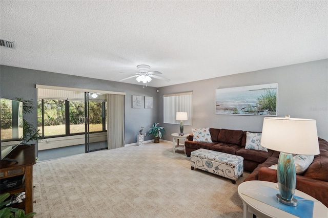 carpeted living area featuring baseboards, ceiling fan, visible vents, and a textured ceiling