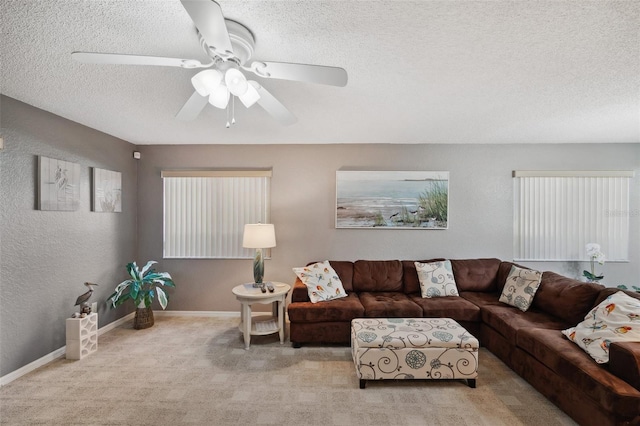 carpeted living area with a textured ceiling, a textured wall, ceiling fan, and baseboards