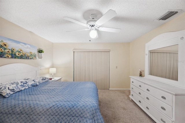 bedroom with light carpet, a textured ceiling, visible vents, and a ceiling fan