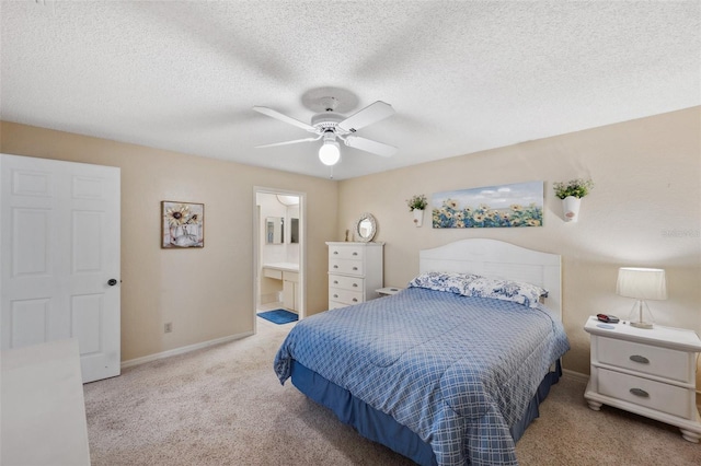 carpeted bedroom with ceiling fan, a textured ceiling, baseboards, and ensuite bathroom