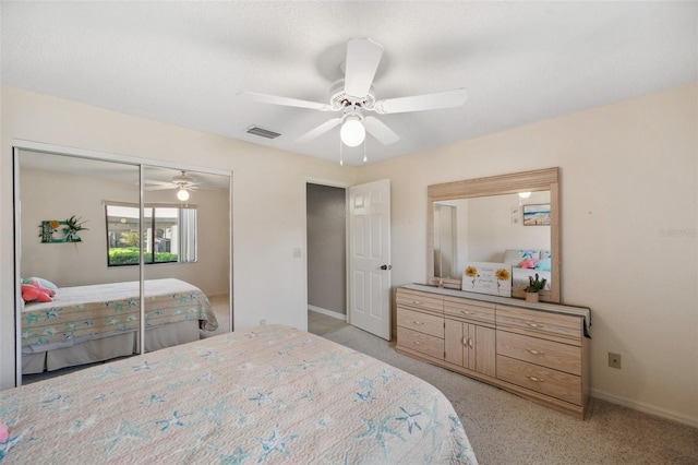 bedroom featuring a closet, light colored carpet, visible vents, a ceiling fan, and baseboards