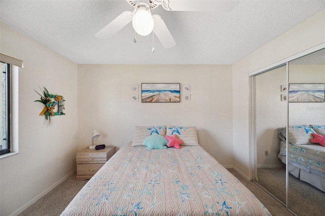 carpeted bedroom featuring baseboards, a textured ceiling, a ceiling fan, and a closet