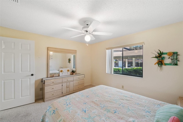 bedroom with light carpet, a textured ceiling, and a ceiling fan