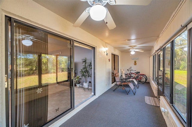 unfurnished sunroom featuring a healthy amount of sunlight and ceiling fan