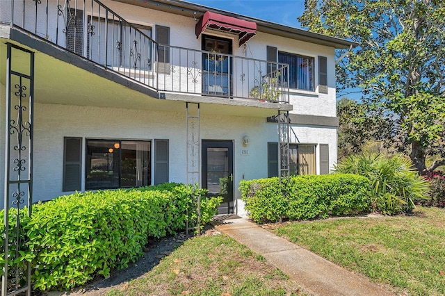 view of front of home with a balcony and stucco siding