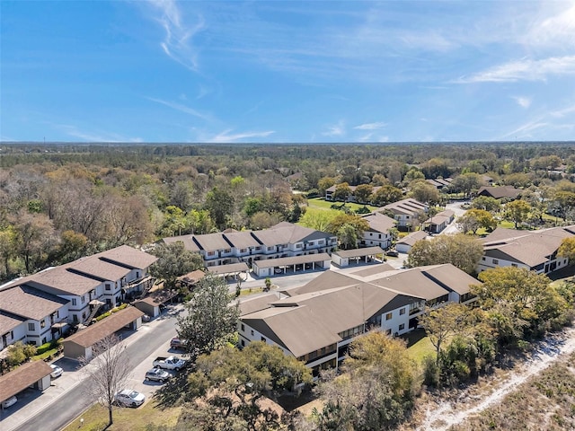 drone / aerial view featuring a residential view and a view of trees