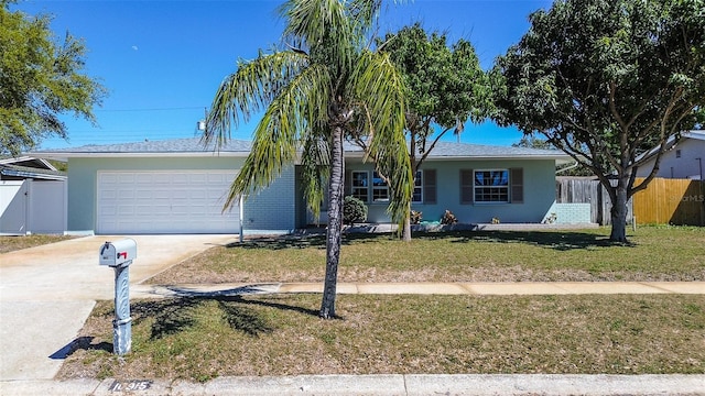 ranch-style house featuring stucco siding, concrete driveway, an attached garage, fence, and a front lawn