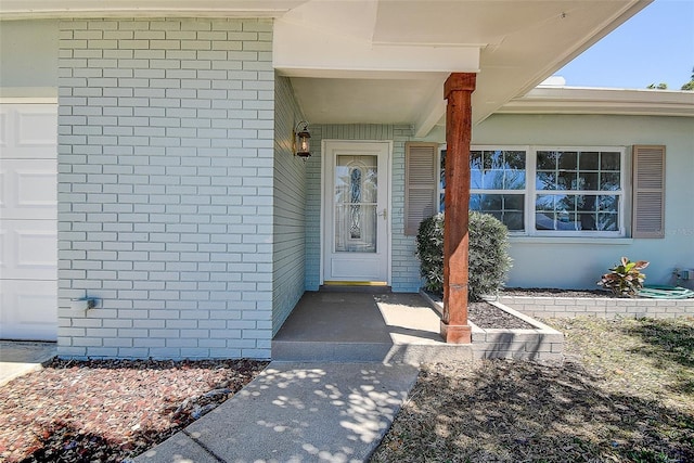 view of exterior entry featuring brick siding