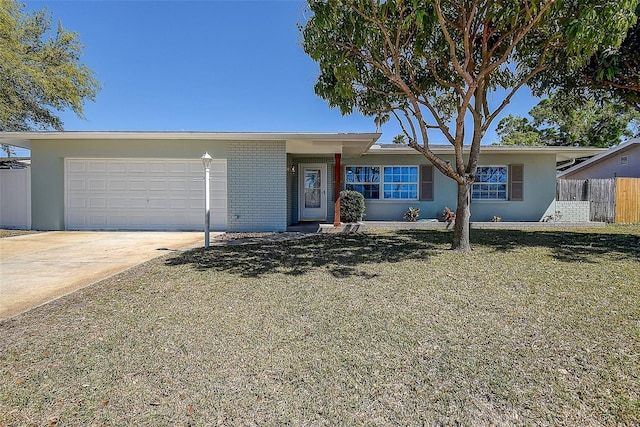 single story home with a garage, concrete driveway, fence, a front lawn, and brick siding