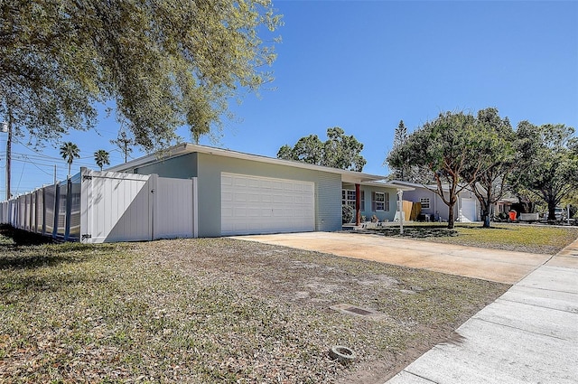 view of front of home with a garage, a gate, driveway, and fence