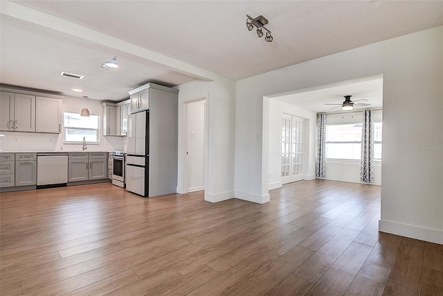 kitchen with visible vents, appliances with stainless steel finishes, open floor plan, gray cabinetry, and light wood-style floors