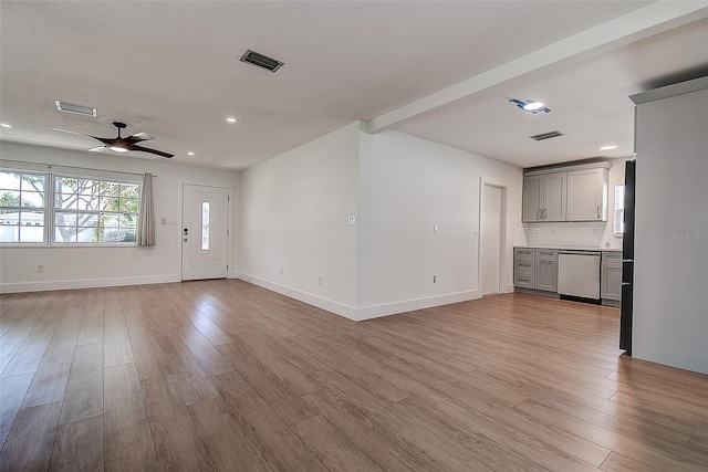 unfurnished living room with ceiling fan, light wood finished floors, visible vents, and baseboards