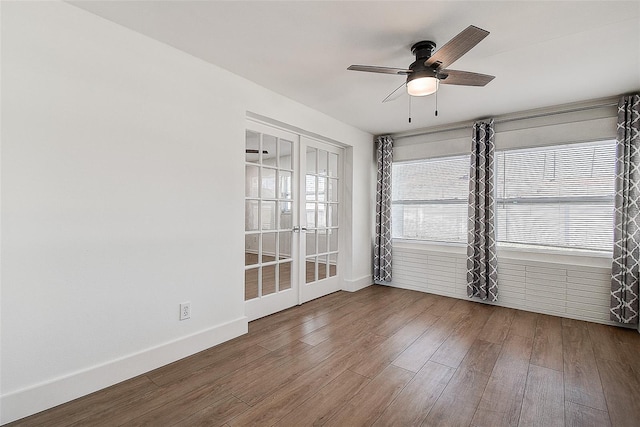 empty room with french doors, ceiling fan, baseboards, and wood finished floors