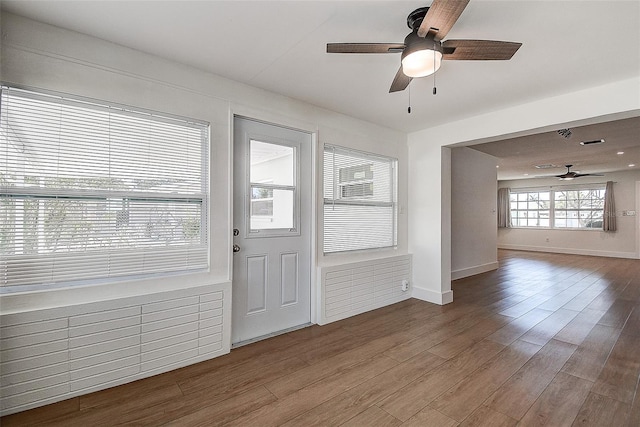 interior space featuring wood finished floors, a ceiling fan, and baseboards