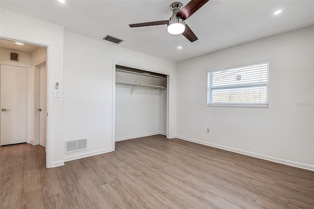 unfurnished bedroom with light wood-style flooring, a closet, visible vents, and baseboards