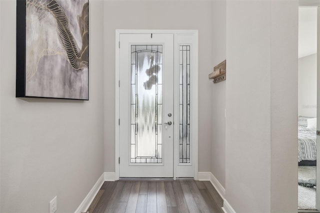 foyer entrance with wood-type flooring and baseboards