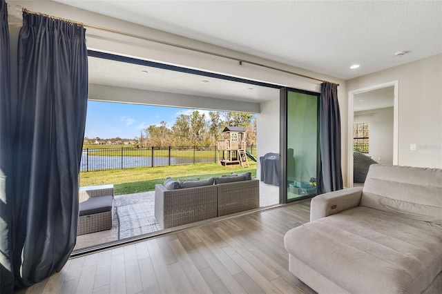 sitting room featuring a water view and wood finished floors