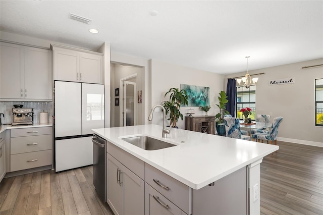 kitchen featuring gray cabinets, visible vents, a sink, and dishwasher