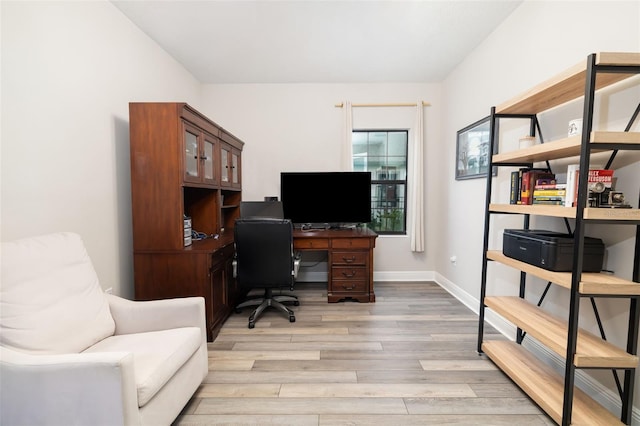 home office with baseboards and light wood finished floors