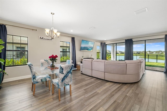 dining space featuring a chandelier, recessed lighting, wood finished floors, and baseboards