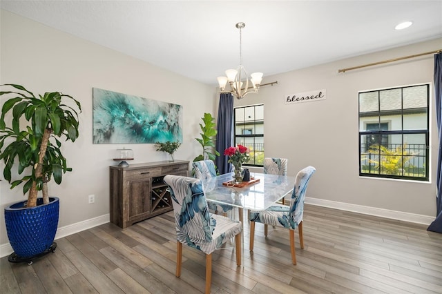 dining room featuring an inviting chandelier, baseboards, wood finished floors, and recessed lighting