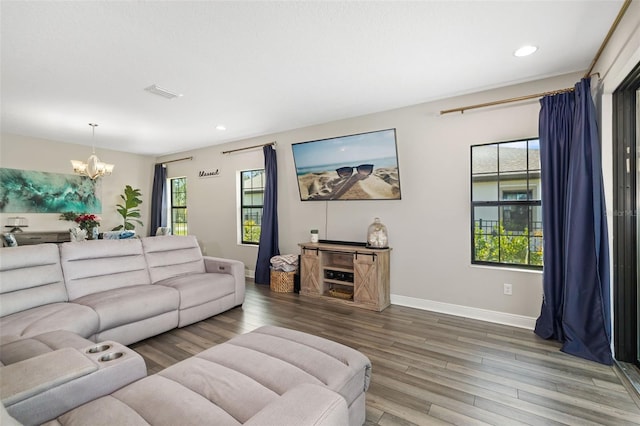 living area featuring a notable chandelier, recessed lighting, visible vents, wood finished floors, and baseboards