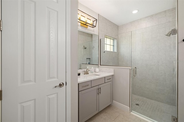 full bathroom with a shower stall, vanity, and tile patterned floors