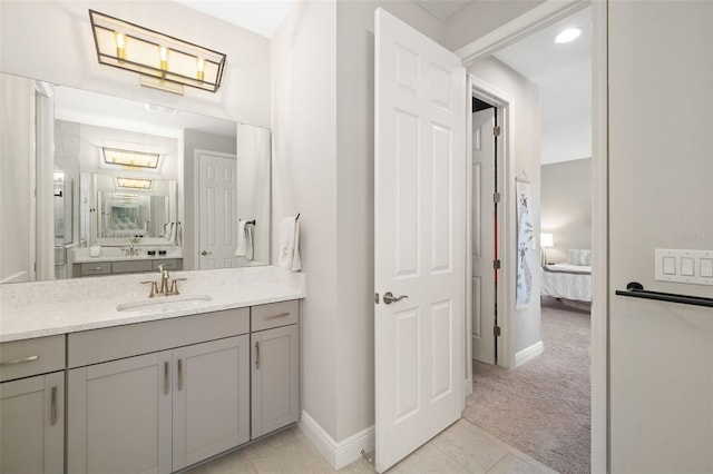 bathroom with tile patterned floors, baseboards, connected bathroom, and vanity