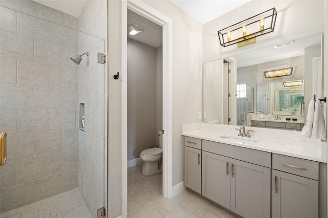 bathroom with toilet, a stall shower, vanity, baseboards, and tile patterned floors