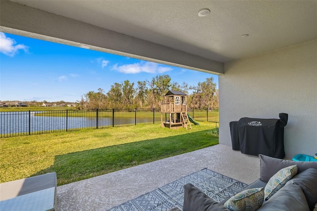 view of patio / terrace with outdoor lounge area, a water view, a playground, and a fenced backyard