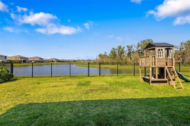 exterior space featuring a lawn, a water view, and a fenced backyard