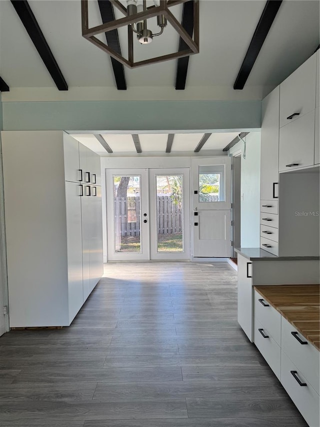 interior space with modern cabinets, beam ceiling, and white cabinetry