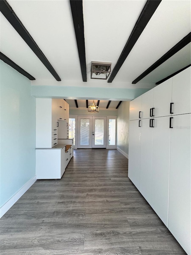 interior space with french doors, dark wood-type flooring, beamed ceiling, and baseboards